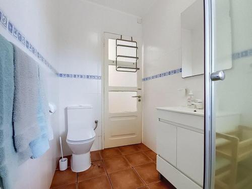 a white bathroom with a toilet and a sink at Casa Varanda das Furnas in Furnas