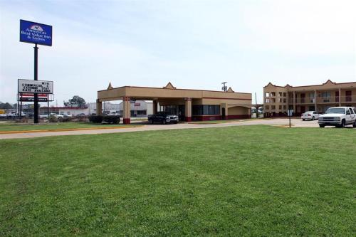 a building with a parking lot and a green field at Americas Best Value Inn and Suites Greenwood in Greenwood