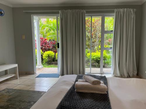 a bedroom with a large bed with towels on it at Luxury Suites on Santorini in East London