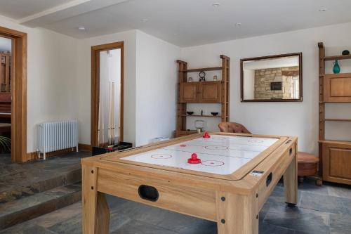 a ping pong table in the middle of a room at Tranquility House in Painswick