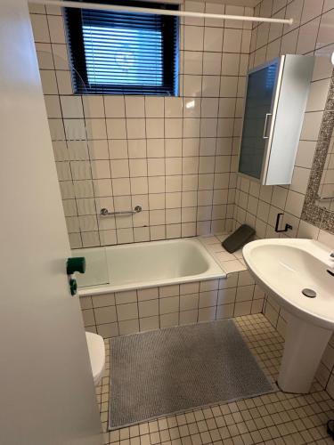 a bathroom with a tub and a sink at Le Papillon in Hotton