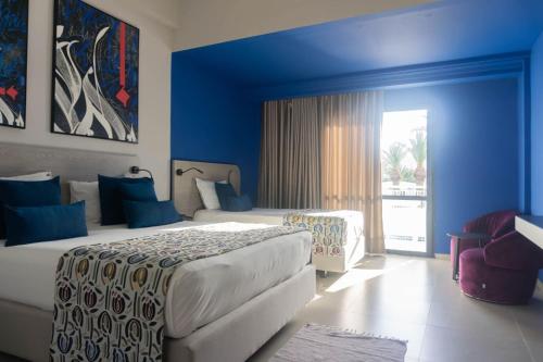 a bedroom with two beds and a blue wall at Golf Residence- Families and Couples Only in Hammam Sousse