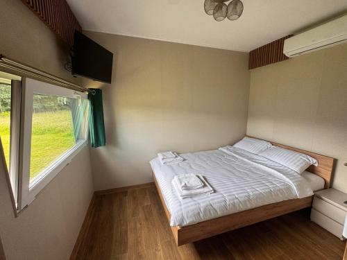 a small bedroom with a bed and a window at Wiatrowe Domki in Lądek-Zdrój