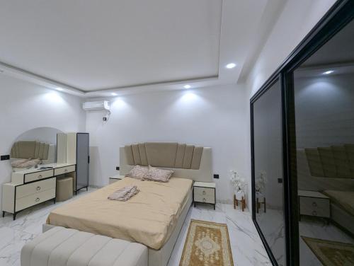 a bedroom with a large bed and a mirror at Azmouni in Midoun