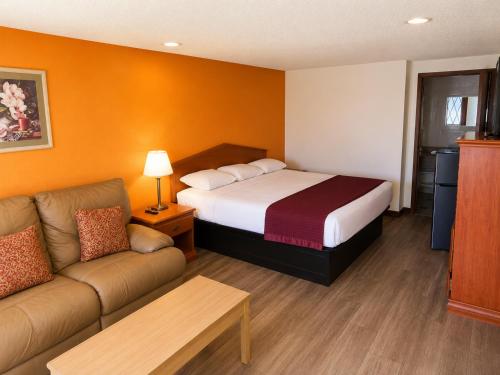 a hotel room with a bed and a couch at Sunrise Inn - Bradenton in Bradenton