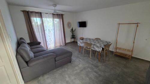 a living room with a couch and a table at Le chant des vagues in Saint-Philippe