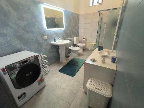 a bathroom with a sink and a washing machine in it at Casa Gelso Rosso in Leni