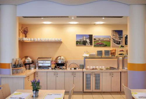 a kitchen with tables and chairs in a restaurant at Hotel Kolping Wien Zentral in Vienna