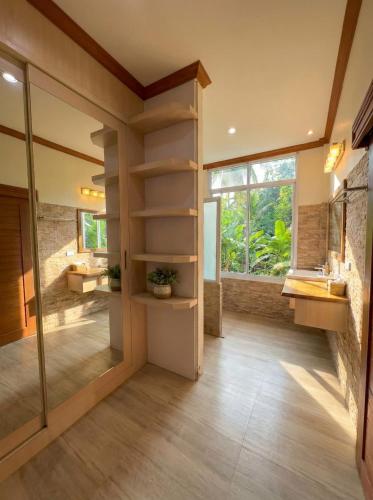 a bathroom with wooden floors and a large glass door at Srithanu sea Villa in Srithanu