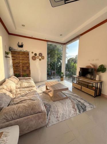 a bedroom with a bed and a table and a television at Srithanu sea Villa in Srithanu