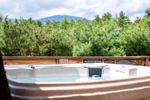 a bathtub in a porch with trees in the background at Large Luxury Home, Close to Whiteface, Lake Placid in Wilmington