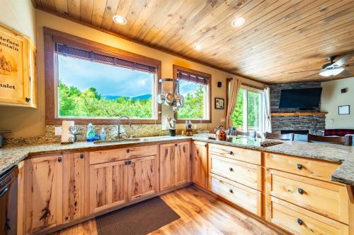 a kitchen with wooden cabinets and a large window at Large Luxury Home, Close to Whiteface, Lake Placid in Wilmington