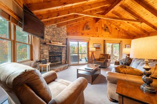 a living room with couches and a stone fireplace at Mountain Home, Views, Near Whiteface, Lake Placid in Wilmington
