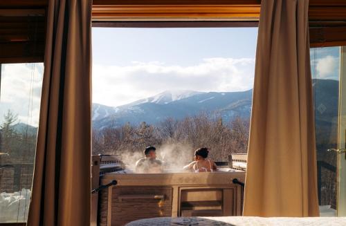 a man and woman in a bath tub with a view at Breathtaking Views Near Lake Placid and Whiteface in Wilmington
