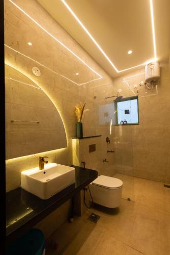 a bathroom with a sink and a toilet and a mirror at Luxury 3BHK Villa with Private Pool & PS5 in North in Socorro