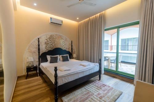 a bedroom with a bed and a large window at Luxury 3BHK Villa with Private Pool & PS5 in North in Socorro