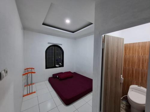a bathroom with a bed and a toilet in it at YouYouKe Pavillon Karangpapak in Cilauteureun