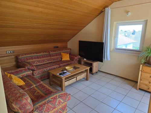 a living room with two couches and a flat screen tv at Ferienwohnung Auf der Warthe in Florstadt