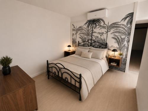 a bedroom with a bed with a mural of palm trees at appartement de la voie verte in Hauterive