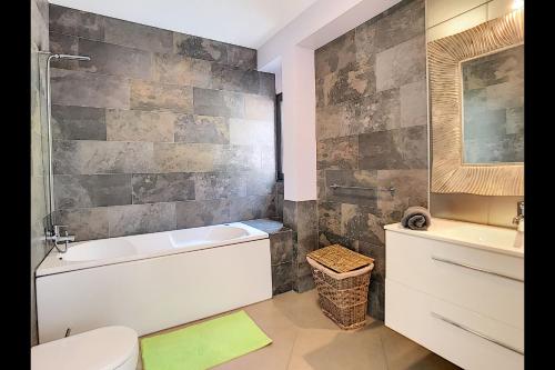 a bathroom with a tub and a toilet and a sink at Villa do Paul by LovelyStay in Paul do Mar