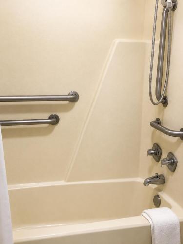 a bathtub in a bathroom with two towel bars at Sunrise Inn - Bradenton in Bradenton