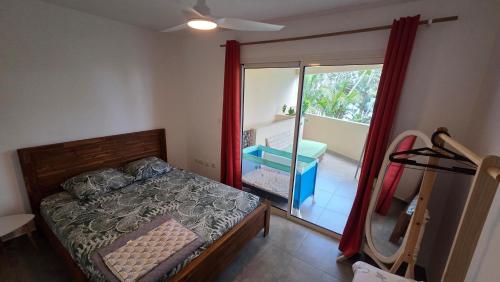 a bedroom with a bed and a sliding glass door at le Chant des vagues 1 in Saint-Philippe