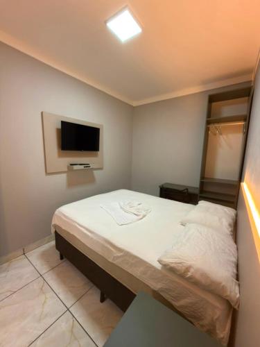 a bedroom with a bed and a flat screen tv at Du Vale Hotel in Tomé-Açu
