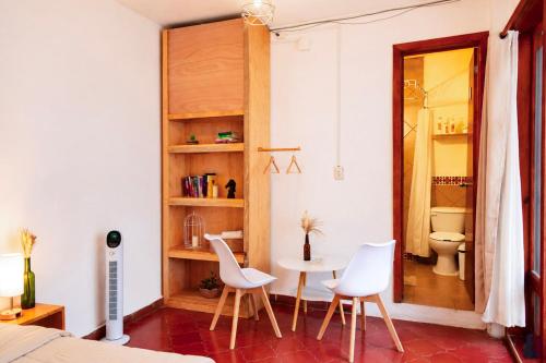 a room with a table and chairs and a toilet at Che San Cristobal de las Casas Hostel in San Cristóbal de Las Casas