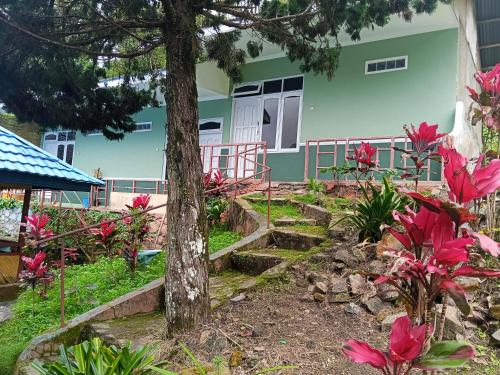 a house with pink flowers in front of it at Kelimutu Lodge in Kelimutu