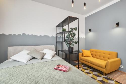 a bedroom with a bed and a yellow chair at Homly S22 in Riga