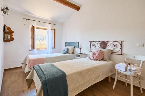 a bedroom with two beds and a window at CasaBianchini Charming Home Val d'Orcia in Monticchiello