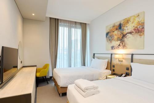 a hotel room with two beds and a television at Bomonti Suites Istanbul in Istanbul