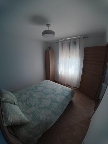 a bedroom with a bed and a window at Cosy et Calme in Cholet