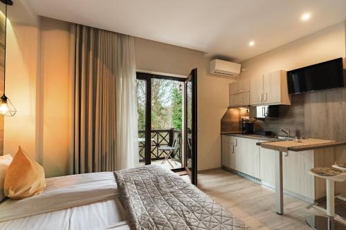 a hotel room with a bed and a kitchen at Amethyst in Sovata