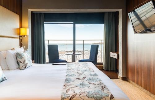 a hotel room with a bed and a view of the ocean at Hotel Ambassadeur in St. Clements