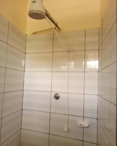 a bathroom with a shower with a toilet in it at Mama Maendeleo Resort in Hindi