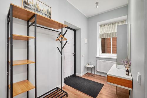 a hallway with a door leading to a bathroom with a sink at Homly S22 in Riga