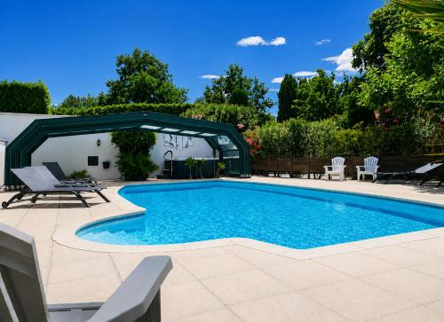 a swimming pool in a yard with chairs at Residence Melody - Adult only in Saint-Rémy-de-Provence