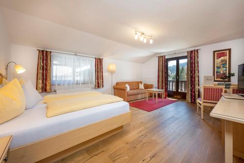 a bedroom with a bed and a living room at Gasthof Kleefeld in Strobl