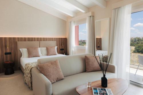 a bedroom with a bed and a couch and a table at PALAZZO RUBINO Aparthotel in Olbia