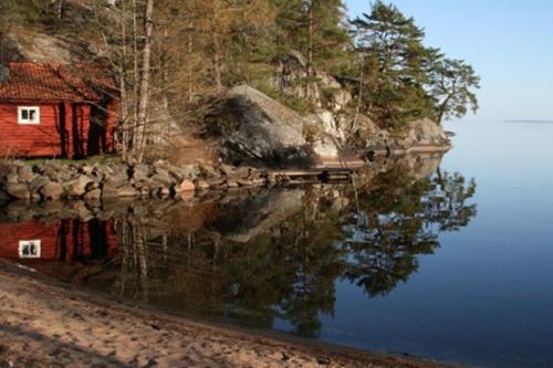a house on the shore of a body of water at Tivedens Hostel-Vandrarhem in Karlsborg