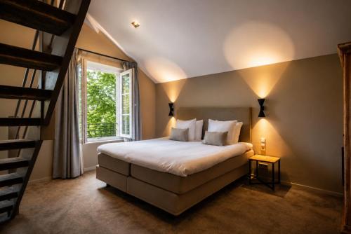 a bedroom with a large bed and a staircase at Hotel Winselerhof by Flow in Landgraaf