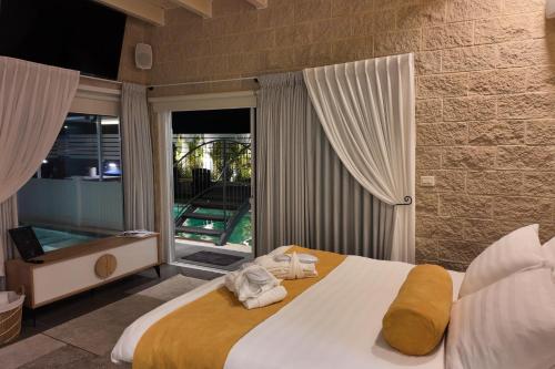 a bedroom with a large bed with towels on it at אחוזת מיא - סוויטות בוטיק על המים in Goren
