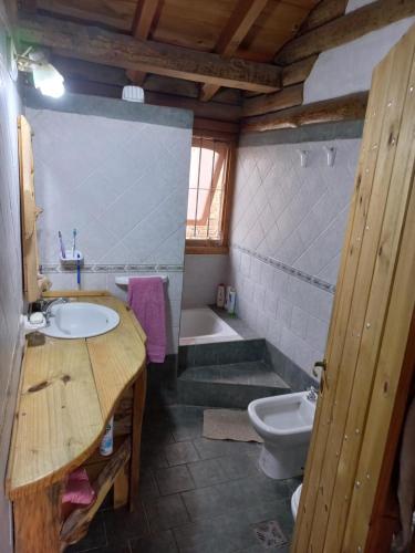 a bathroom with a sink and a toilet and a tub at El Rancho in Villa Giardino