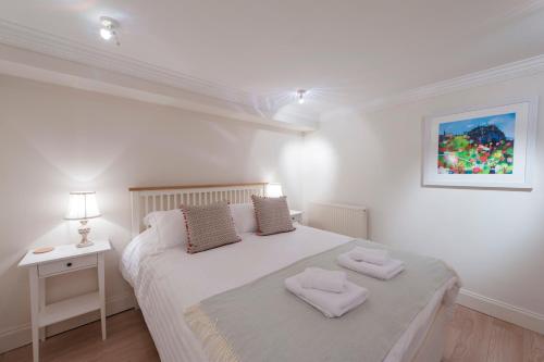 1 dormitorio con 1 cama blanca y 2 toallas en Apartment Jamaica Street 7, en Edimburgo