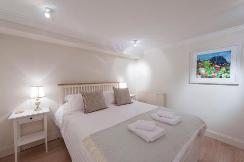 a bedroom with a white bed with two towels on it at Apartment Jamaica Street 7 in Edinburgh