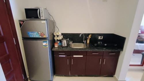 a small kitchen with a sink and a refrigerator at Oyster Bay Beach Suites K7-14 in Marsa Alam City