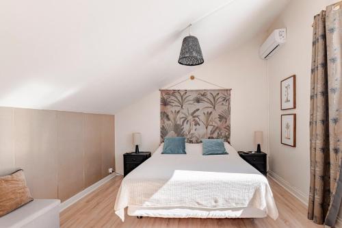 a bedroom with a large white bed with blue pillows at KAZUBUNTU in Saint-Leu