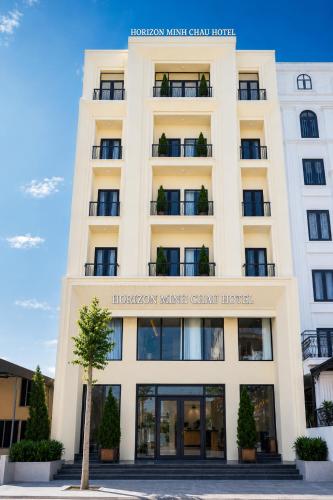 a large white building with a sign on it at Horizon Minh Chau Hotel in Quang Ninh