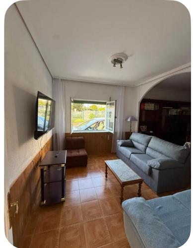 a living room with a couch and a table at El Rincón de pedreña in Pedreña